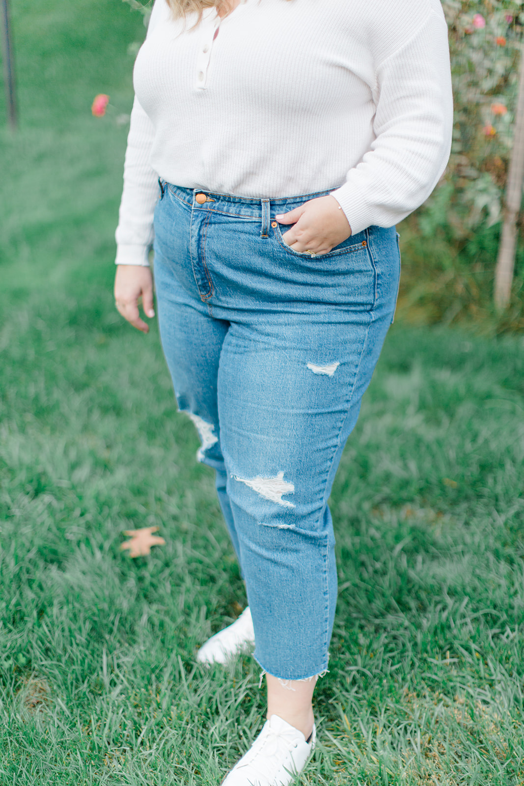 a woman wearing tennis Shoes With Straight Leg Jeans and white long sleeve top