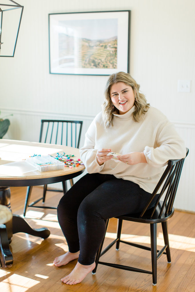 smiling plus size woman wearing black leggings and a cream turtleneck sweater