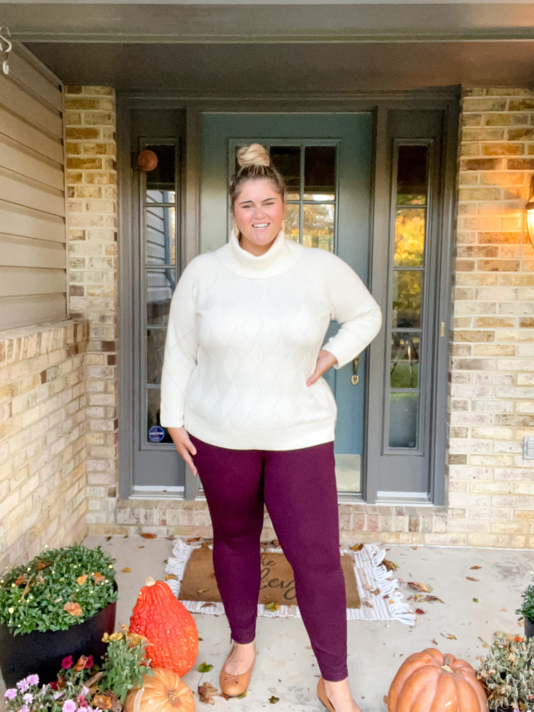 a blonde woman modeling a plus size leggings outfit of burgundy leggings and a cream sweater