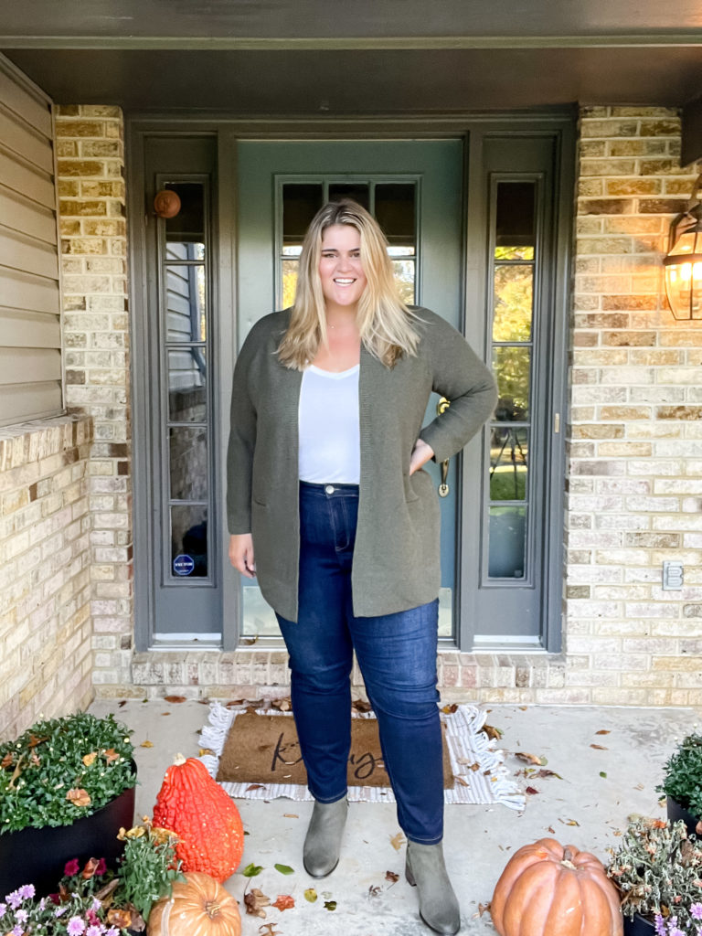 a plus size blonde woman wearing jeans, white tee, cardigan and ankle boots