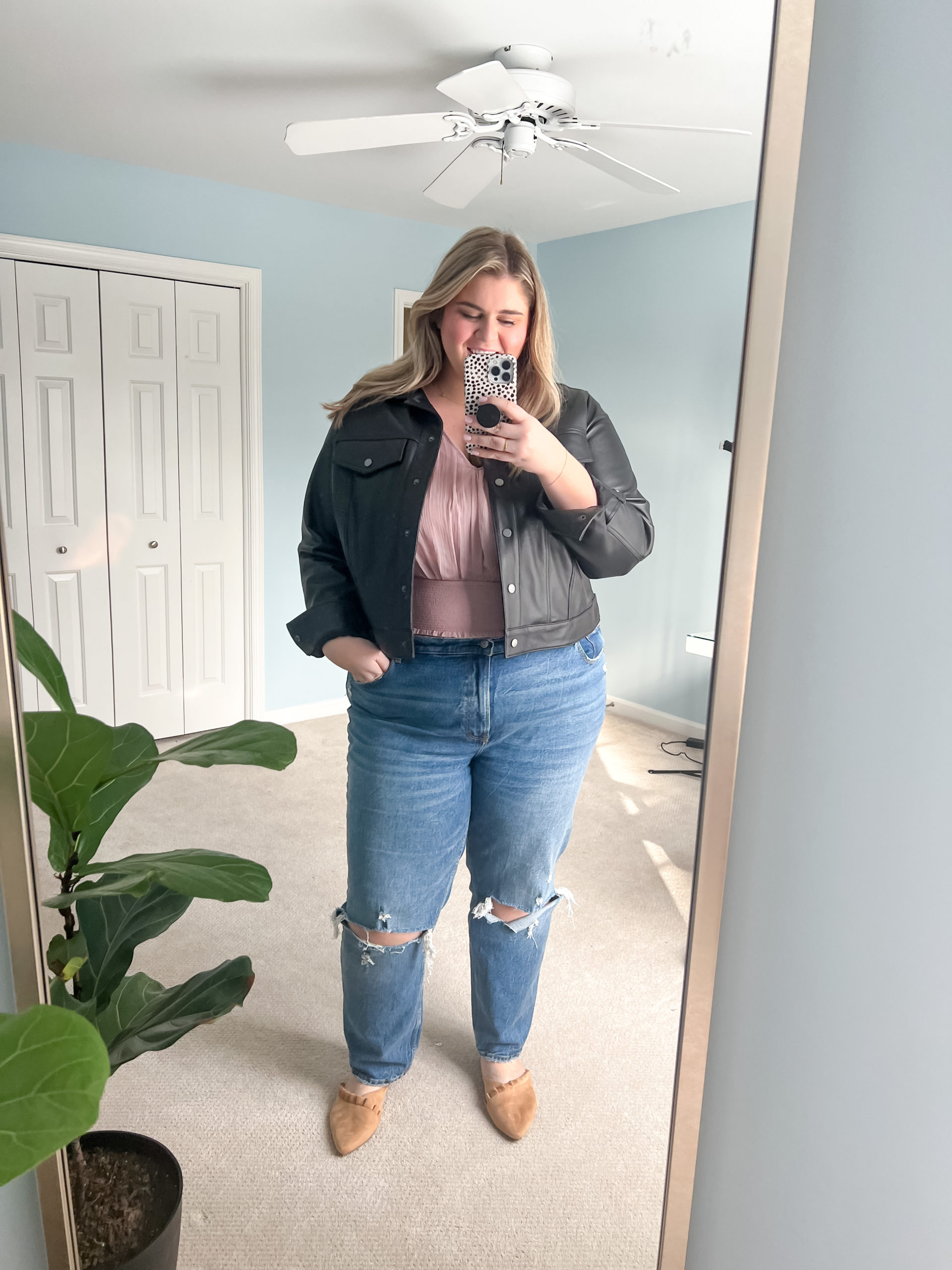 a plus size Caucasian woman taking a mirror selfie wearing pointy Shoes With Straight Leg Jeans and a black jacket