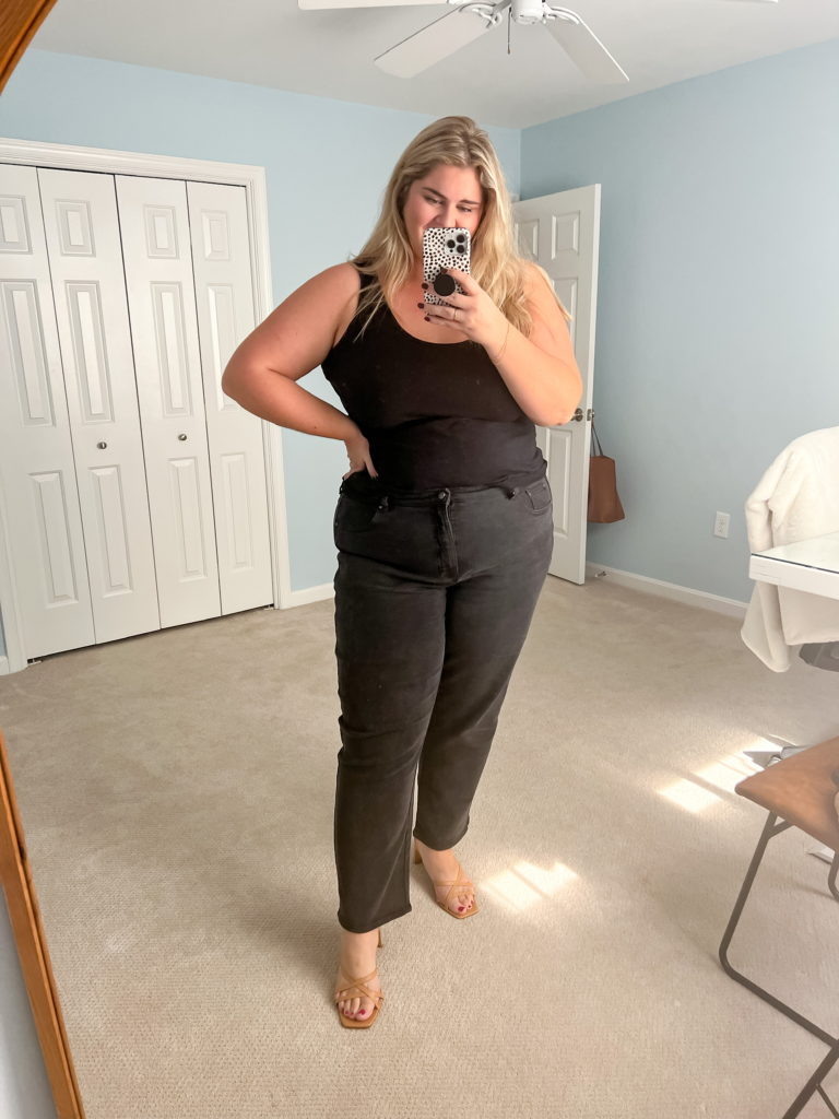 plus size blonde woman with fair skin wearing black straight leg jeans and heels