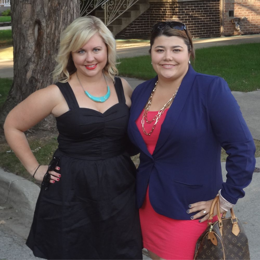 Two Caucasian women pose for a picture outside while modeling a jacket that goes with dresses. 