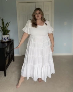 blonde white woman wearing a plus size white bridal shower dress in her bedroom